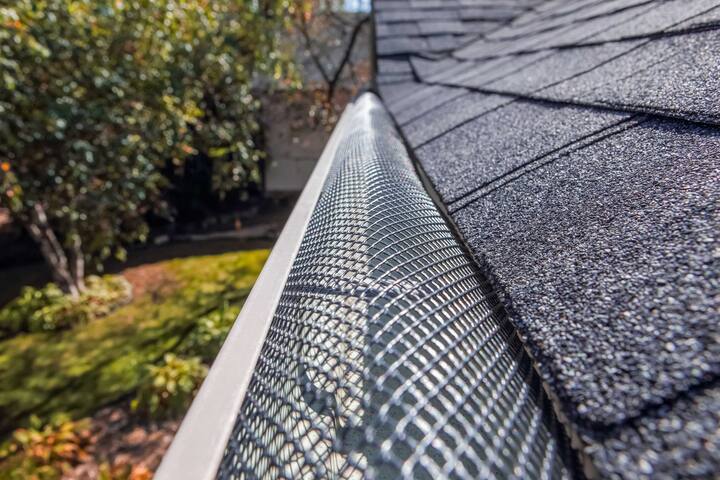 A contractor demonstrating the effectiveness of a gutter guard to a potential client in New Braunfels
